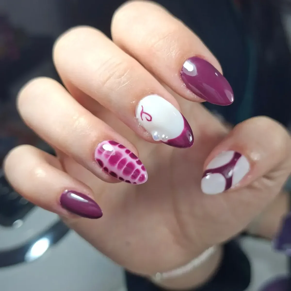 Detalle de manicura borgoña con diseño